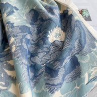 Luxurious reversible wrap in soft blue and cream floral design, perfect for elevating any outfit with elegant drape.