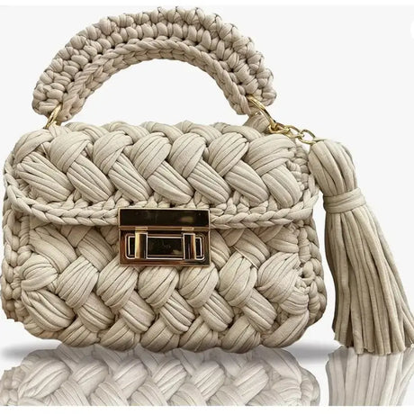 Stylish cream crocheted luxury handbag with a braided handle and tassel, perfect for special occasions.
