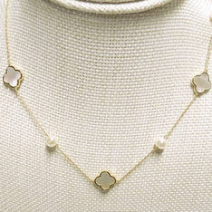 Necklace with clover-shaped pendants on a textured beige background