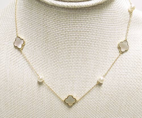 Necklace with clover-shaped pendants on a textured beige background