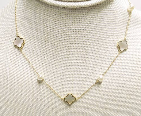 Necklace with clover-shaped pendants on a textured beige background
