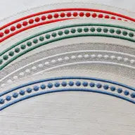 Embroidered round placemat with dots around the corners