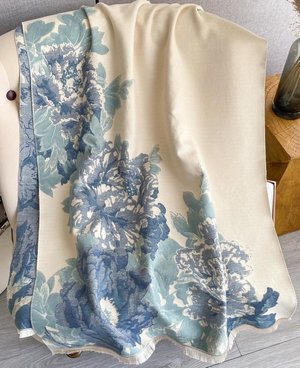 Luxurious reversible soft blue and cream wrap draped elegantly, featuring floral patterns for stylish layering.