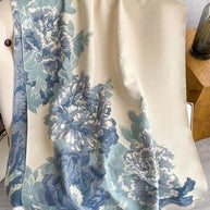 Luxurious reversible soft blue and cream wrap draped elegantly, featuring floral patterns for stylish layering.