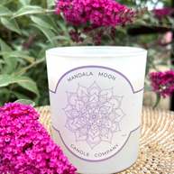 Candle with Mandala Moon Candle Company label surrounded by pink flowers