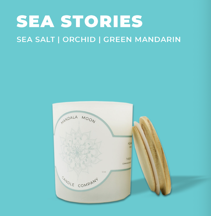 Candle with wooden lid on a light blue background, featuring 'Sea Stories' scents.