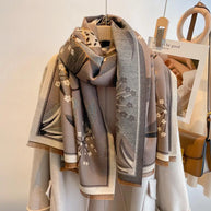 Luxurious reversible tan and gray Garden Bloom Wrap elegantly draped on a coat for a sophisticated layered look.